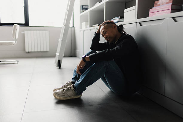 istock Exhausted office worker resting on the floor by cabinets after a long day in a modern workspace 2239914801
