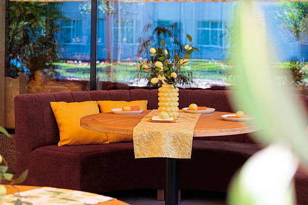 istock interior patio restaurant space furniture soft sofa with pillows and table served with plates and flower vase on surface yellow and brown colors environment decoration space summer time 2239916002