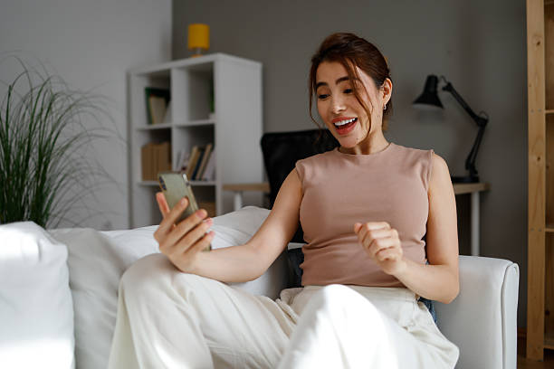 istock Woman making surprised video call on smartphone at home 2239917086