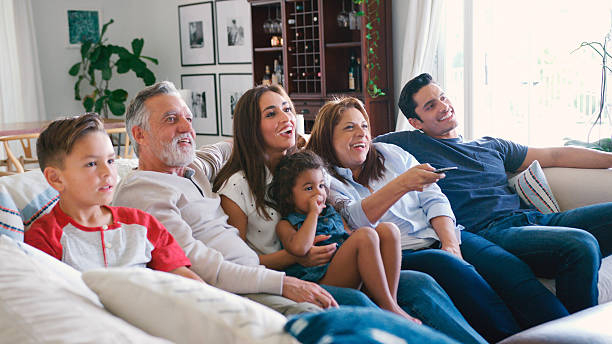 istock Multi-Generation Family Sitting On Sofa At Home Watching TV Together 2239925248