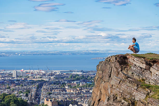 istock Tourist perched on cliff, taking in urban landscape and ocean 2239925283