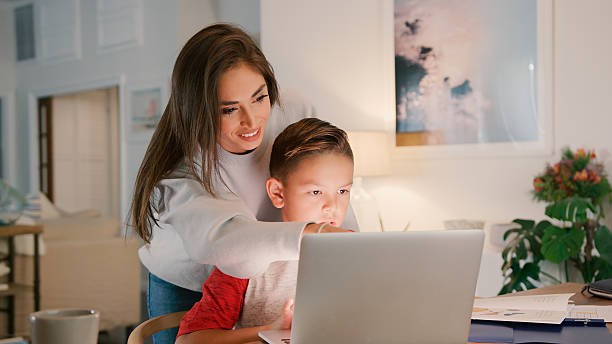 istock Mother Helping Son Studying Using Laptop At Home Together 2239925313
