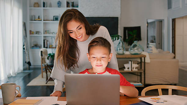 istock Mother Helping Son Studying Using Laptop At Home Together 2239925337