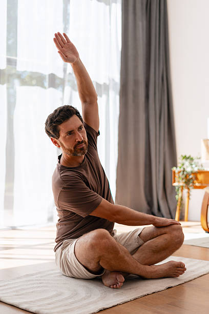 istock Middle aged man practicing yoga stretching exercise indoors, morning routine concept 2239925998