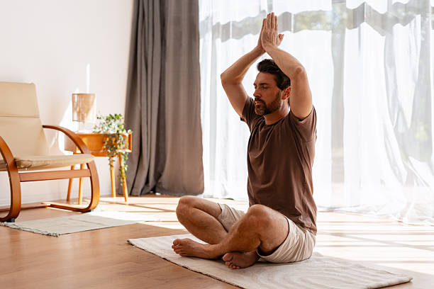 istock Middle aged man practicing yoga meditation indoors 2239926002
