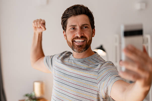 istock Happy bearded Latin man flexing arm taking selfie indoors having video conference 2239926043