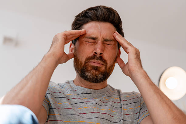 istock Stressed bearded Latin man suffering from intense headache pain 2239926062