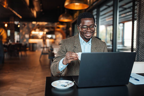 istock Man with Laptop Enjoying Coffee in a Cafe 2239928542