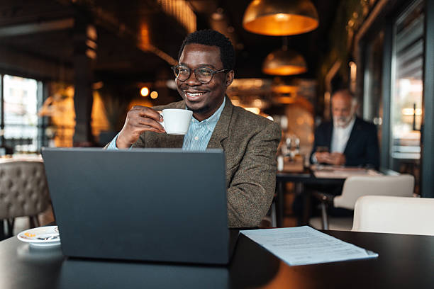 istock Confident man with coffee smiling at laptop 2239928562