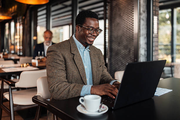 istock Happy Man Working on a Laptop in a Cafe 2239928592