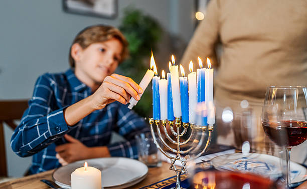 istock Boy lighting candles on menorah for Hanukkah celebration 2239928601