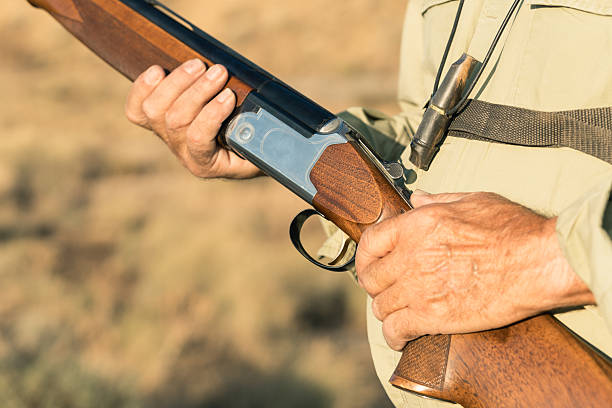 istock Senior hunter holding a shotgun outdoors, ready 2239928722