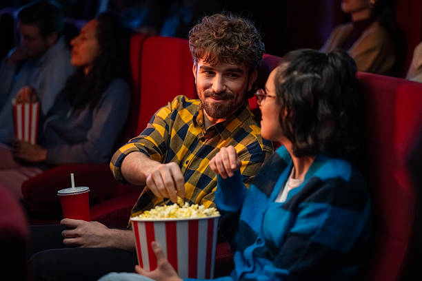 istock Young Hispanic Couple Relaxing with Popcorn in a Cinema 2239930079