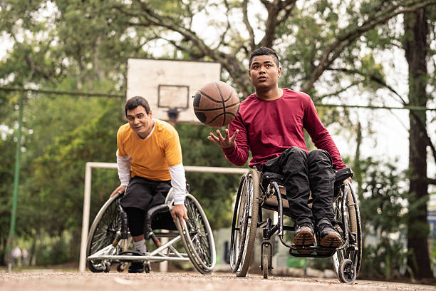 istock wheelchair men playing basketball outside. 2239933191