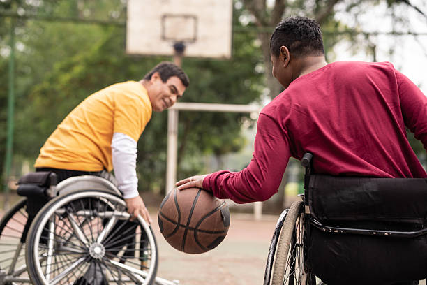 istock wheelchair man playing basketball outside. 2239933206