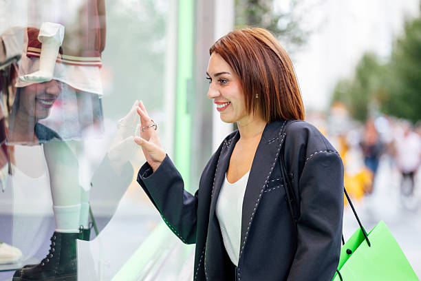 istock Woman smiling while window shopping on street 2239933302