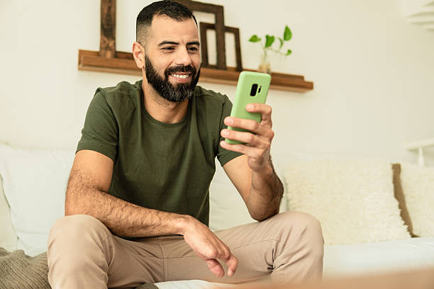 man with partial hand amputation smiling and looking at cell phone screen