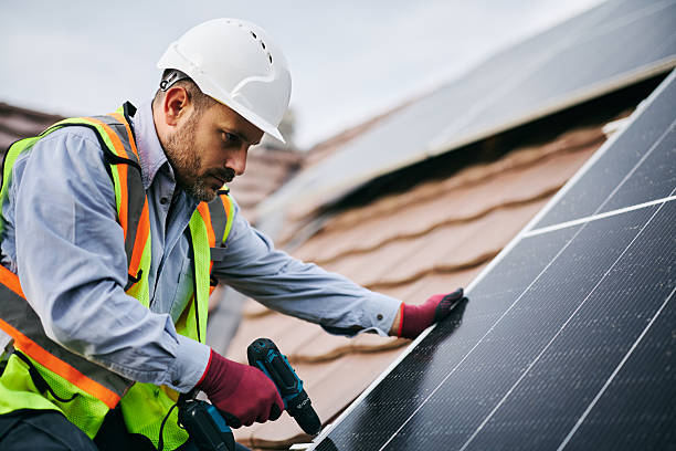 istock Male engineer securing solar panels to the mounting system on the roof. 2239934338