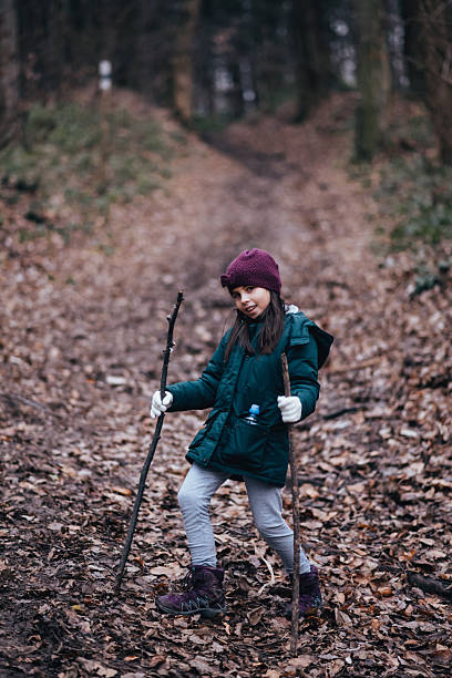 istock Girl walking forest path holding sticks exploring nature 2239938178