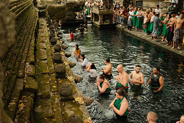 People standing in holy spring water at Tirta Empul, Bali, performing a traditional Hindu purification ritual
