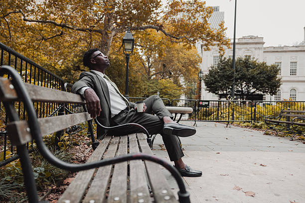 istock Businessman resting on a park bench 2239942650