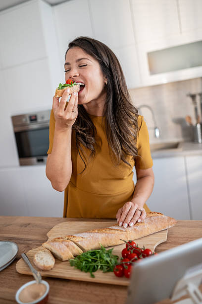 istock Woman enjoying bruschetta while cooking in modern kitchen 2239944558