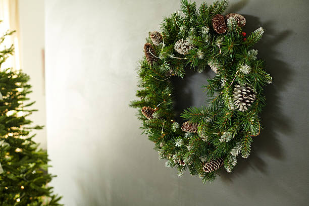 istock Christmas Wreath Hanging on Wall with Pine Cones and Evergreen Branches 2239945045