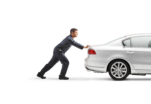 istock Auto mechanic pushing a car 2239945624