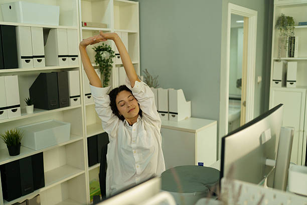 istock An exhausted employee stretches his arms from working hard in the office. 2239946452