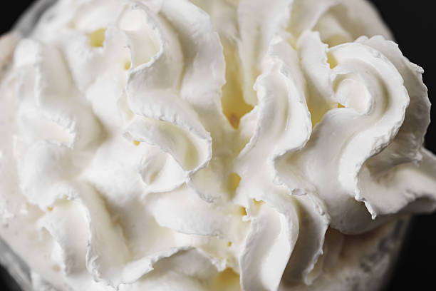 Swirling surface of light beige low-fat milky cream. Close-up photo.