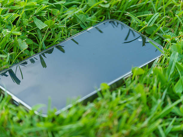 istock Phone on Green Lawn with Sky Reflection 2239947671