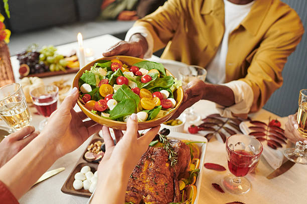 istock Multiethnic Young Adults Sharing Fresh Salad during Thanksgiving Dinner Gathering 2239947752