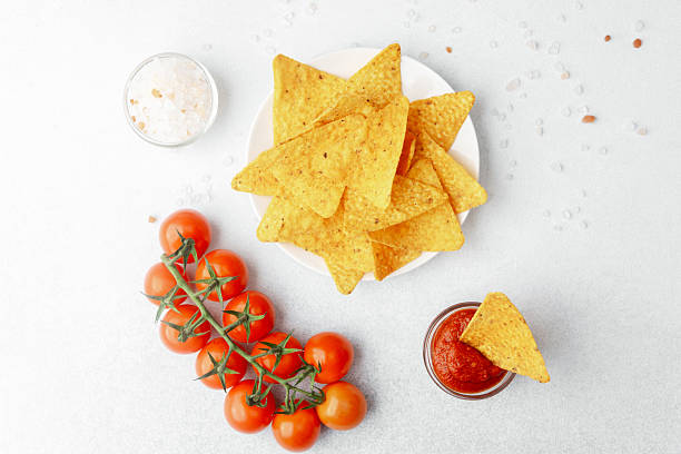 istock Nachos with tomato salsa, salt and fresh cherry tomatoes on white background 2239948289