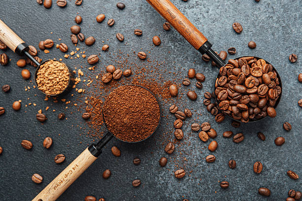 istock Ground coffee and whole beans with scoops on gray background 2239948364