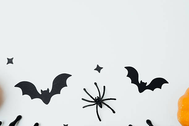 istock Black bats and spider cutouts with pumpkins on a white background for Halloween 2239948371