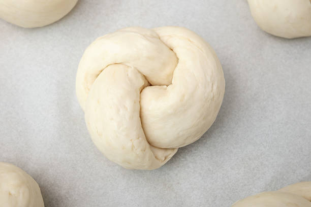 istock Top view of bread knot on baking sheet with paper. 2239949353