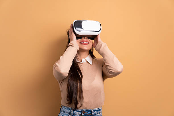 istock happy brunette young woman Using VR headset and gesturing in studio shot. virtual reality, technology simulation concept. 2239951458