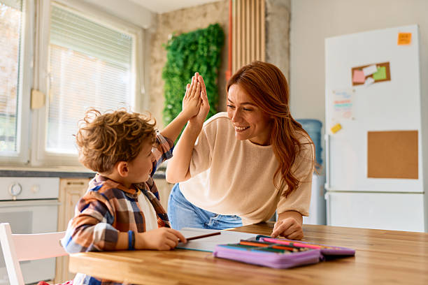 istock Mother and son high-fiving at home after learning 2239951717