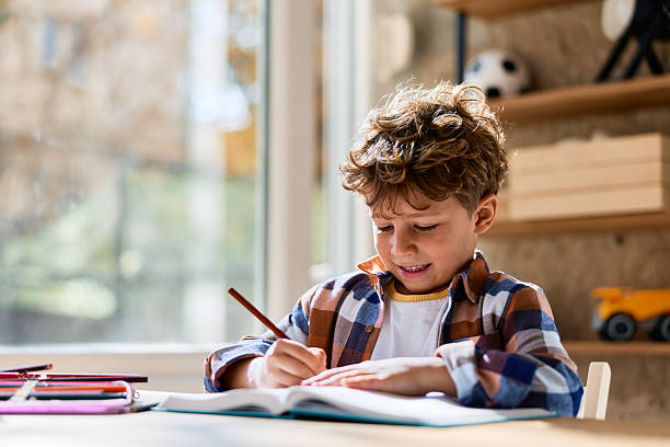 istock Young boy doing homework and studying at home 2239952350