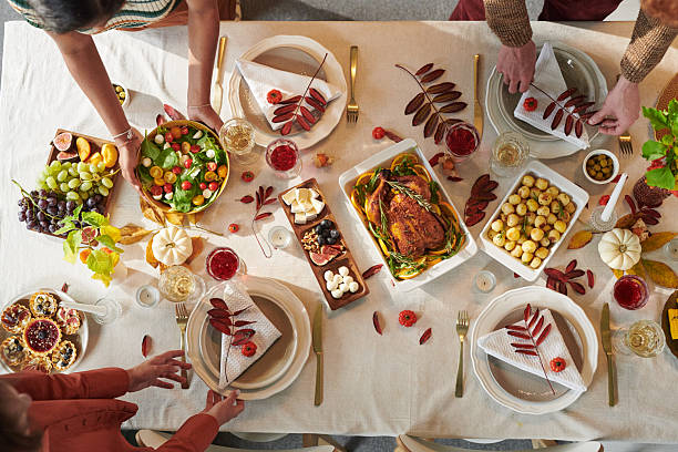 istock Multiethnic Adults Sharing Thanksgiving Meal Around Table during Holiday Gathering 2239952469