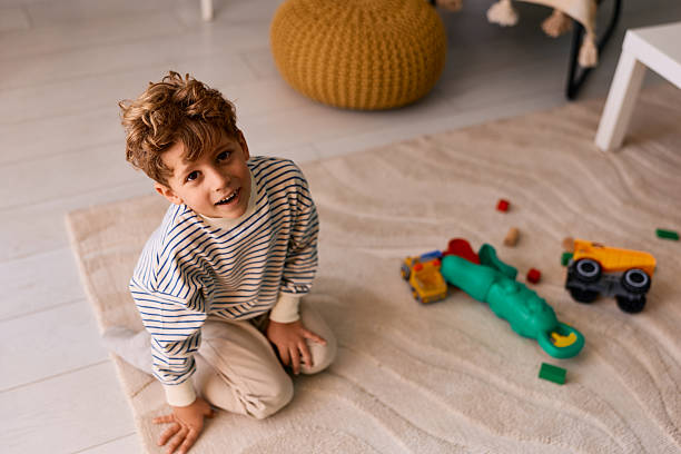 istock Young boy playing with toys on home rug 2239952787