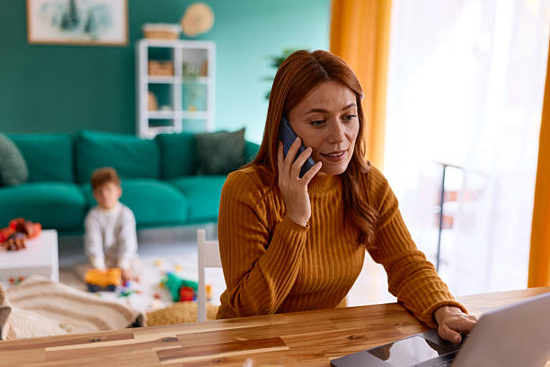 istock Working mother multitasking from home calling on phone 2239952790