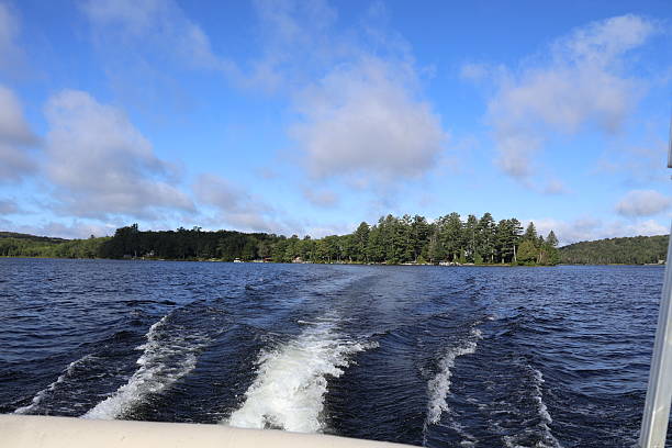 A view of the back of a boat churning up wake as it moves through Canada Lake in the Adirondacks.