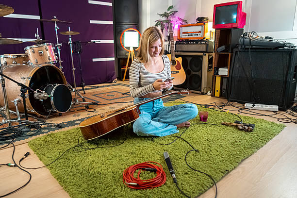 istock Young woman composing music on phone in studio 2239954640