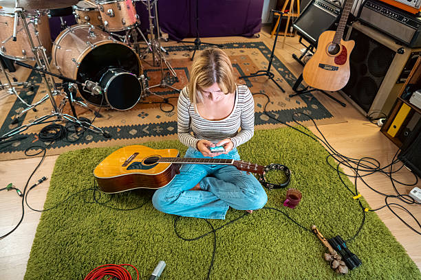 istock Young woman with a guitar composing on a smartphone 2239954655