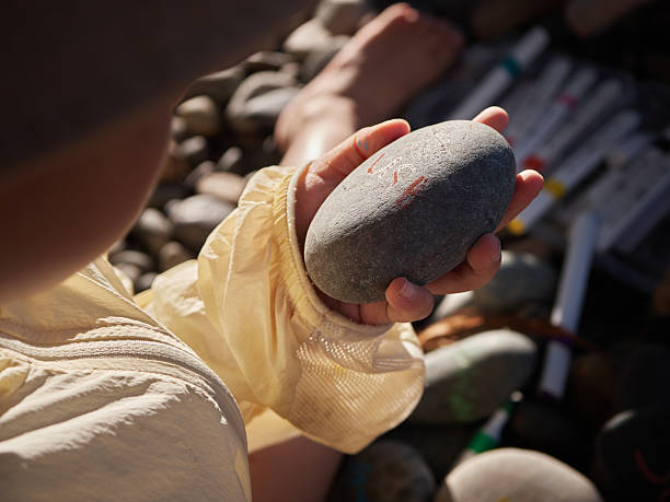 istock Boy Drawing On Pebble By The Lakeside 2239954896