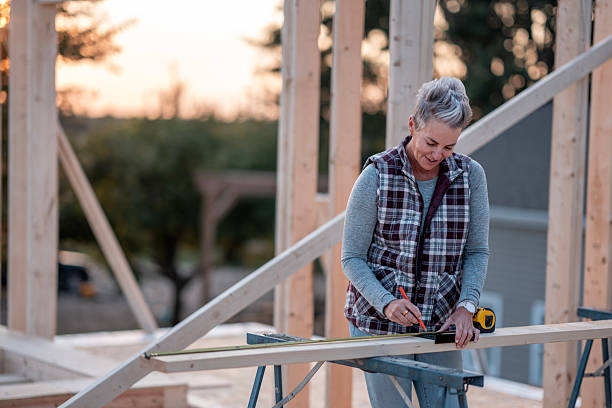 istock Older Woman Builder Measuring Wood On Construction Site With Tools In Hand 2239956714