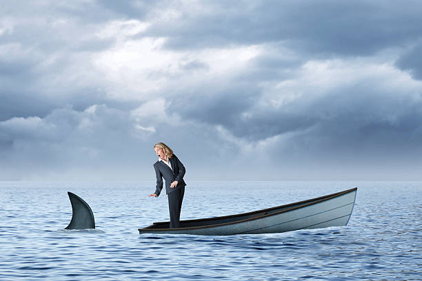 istock Woman In Sinking Boat That Is Being Trailed By A Shark 2239957295