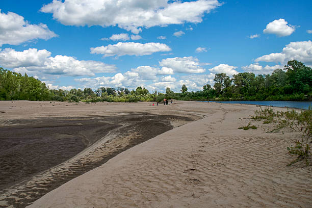 istock Sandy riverbank landscape with blue sky and clouds on a sunny summer day 2239957396