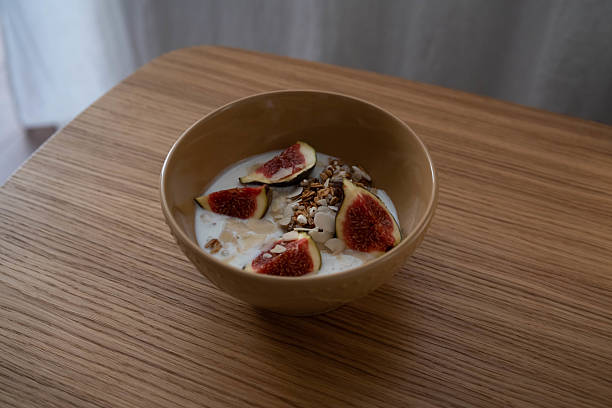 A beautifully arranged yogurt bowl decorated with figs and crunchy granola, which is perfect for a delicious breakfast.